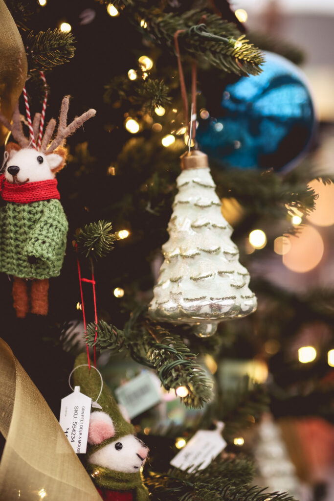 Close-up of white christmas tree ornament among other ornaments on a christmas tree